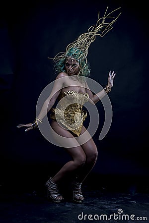 Dancing, Latin woman with green hair and gold costume with handmade flourishes, fantasy image and tale Stock Photo