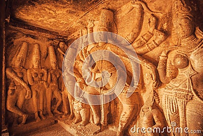 Dancing Shiva Lord sculpture with many dands on wall of old relief. Ancient Indian architecture in Aihole, India Stock Photo