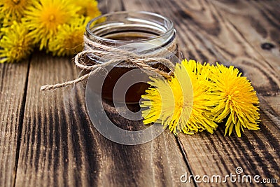 Dandelion jam or honey in jar with fresh flowers Stock Photo