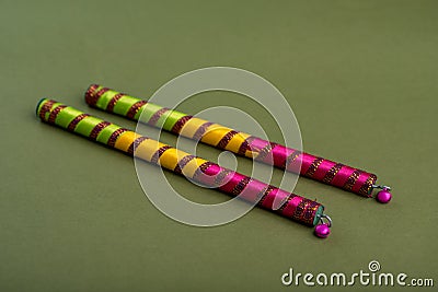 Dandiya sticks on a green background. Raas Garba or Dandiya Raas is the traditional folk dance. Stock Photo