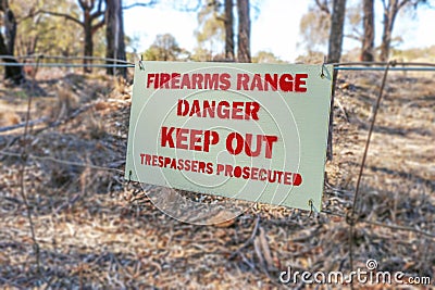 Danger Firearms Range Keep Out Trespassers Prosecuted sign on fence Stock Photo