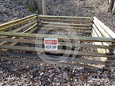 Danger keep off sign on wood fence around mine entrance Stock Photo