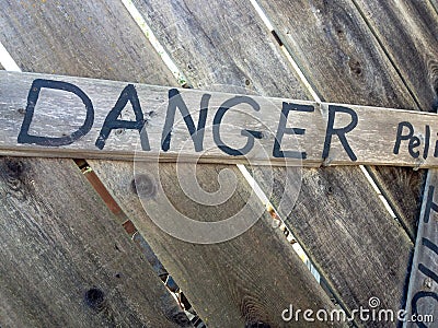 Danger keep out peligro sign painted on wood fence Stock Photo