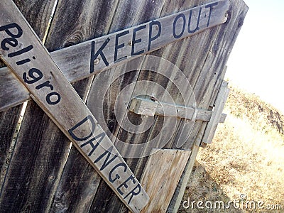 Danger keep out peligro sign painted on wood fence Stock Photo
