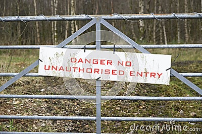 Danger no unauthorised entry sign on gate Stock Photo