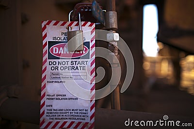 Danger permit isolation tag do not start or operate and locking to control life plant starting up Stock Photo