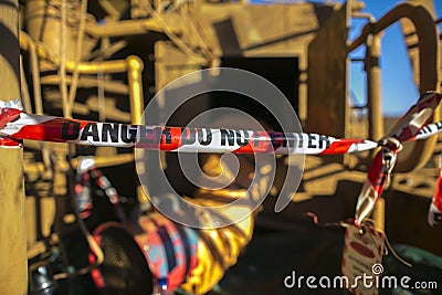 Danger red and white tape barricade exclusion area at confined space entry door authorised personnel only Stock Photo