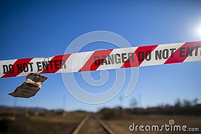 Danger red and white tape barricade exclusion zone area with written authorised personnel entry only on train track Stock Photo