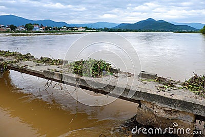 Damaged bridge across flowing river Stock Photo