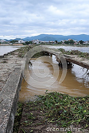 Damaged bridge across flowing river Stock Photo