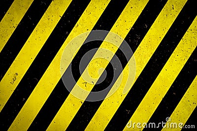 Danger zone: Warning sign yellow and black stripes painted over concrete wall coarse facade with holes and imperfections texture Stock Photo