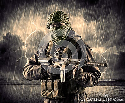 Dangerous armed terrorist with mask and gun in a thunderstorm wi Stock Photo