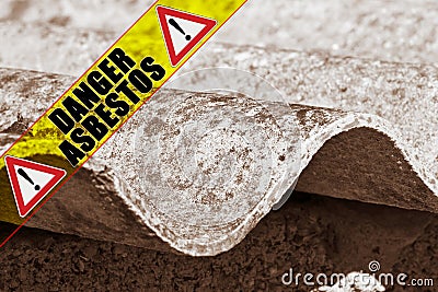 Dangerous asbestos roof with the message danger asbestos written on a yellow stripe Stock Photo