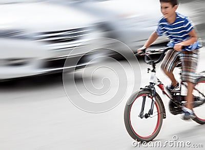 Dangerous city traffic situation with a boy on bicycle Stock Photo