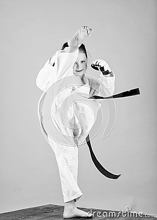 She is dangerous. Girl little child in white kimono with belt. Karate fighter ready to fight. Karate sport concept. Self Stock Photo