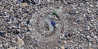 Dangerous glass fragments from broken bottles on the coast of the sea. Glass dangerous trash on the beach Stock Photo