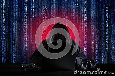Dangerous hacker man in black hooded, masked and gun using computer, breaking into security data and corporate server. He stealing Stock Photo