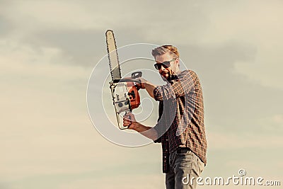 He is dangerous. men brutality and sexuality. Job for real men. sexy man sky background. macho man chain saw tool. male Stock Photo