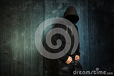 Dangerous unrecognizable faceless criminal standing in front of Stock Photo