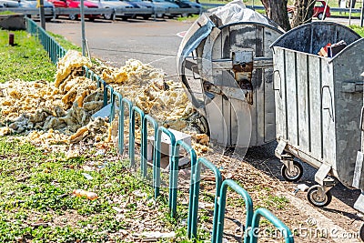 Dangerous waste material dumped on the urban city street near garbage cans polluting and littering environment with hazard junk wa Stock Photo