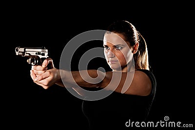 Dangerous woman terrorist dressed in black with a gun in her han Stock Photo