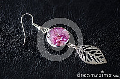 Dangle earrings made of epoxy resin and dried rose petals Stock Photo