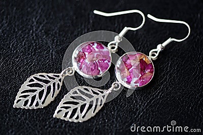 Dangle earrings made of epoxy resin and dried rose petals Stock Photo