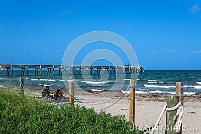 Landscape view of Dania Beach Ocean Park Pier and swimmers on the Atlantic Ocean in southern Editorial Stock Photo