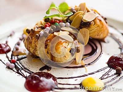 Danish pastry with syrup and sprinkle with almonds and chocolate balls. Stock Photo