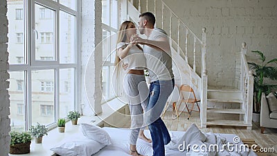 Dança bonita e loving nova dos pares e beijo na cama na manhã em casa video estoque Dança bonita e loving nova dos pares e beijo na cama na manhã em casa video estoque