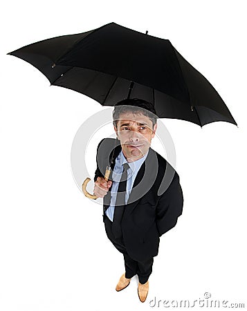 Dapper businessman sheltering under an umbrella Stock Photo