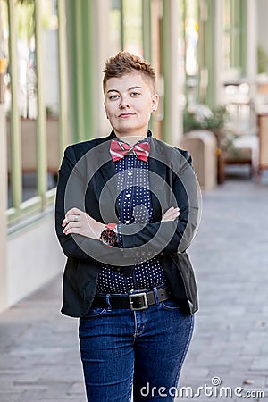 Dapper Gender Fluid Young Woman with Arms Crossed Stock Photo