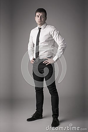 Dapper young business man with hands on hips Stock Photo