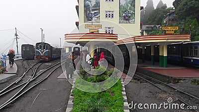 Darjeeling railway station with tourists, toy trains, and porter and toy train track Editorial Stock Photo
