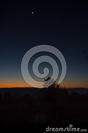 Dark autumn sky at sunrise when the moon shines in the sky Stock Photo