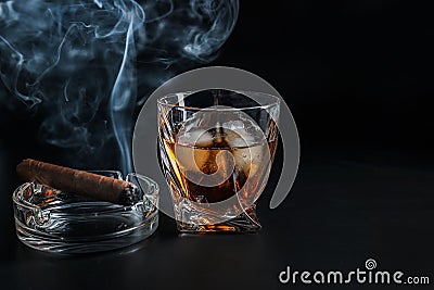 Glass of cold whiskey with cigar on dark background Stock Photo