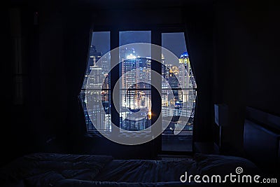 Dark bedroom with light on the skyscrapers Stock Photo