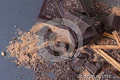 Dark bitter chocolate broken pieces, cocoa powder and cinnamon. Chocolate background Stock Photo