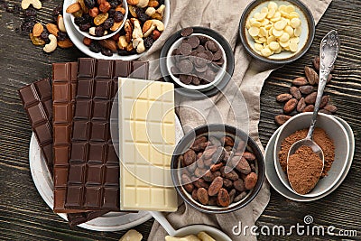 Dark bitter, milk and white chocolate, cocoa butter, cacao powder and beans on wooden table Stock Photo