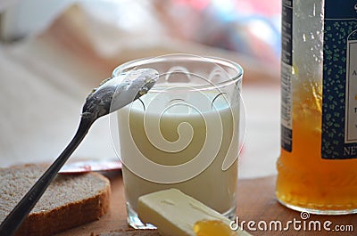 Dark bread ,milk ,butter and apricot jam . Stock Photo