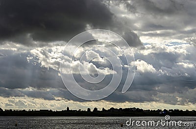 Dark clouds over the river Stock Photo