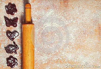 Dark cookie. Ingredients for a sweets recipe. The formation of cookies. Rolling pin for rolling dough. Sprinkle flour on the board Stock Photo