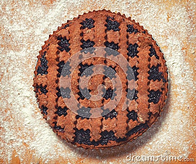 Dark cookie. Stuffed Cocoa Pie. Sprinkle flour on the board. Fresh pie from the oven. Stock Photo