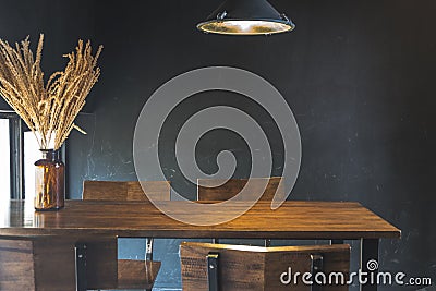 Dark dining table with wooden chair and dry flower Stock Photo