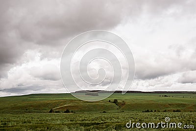 Dark dramatic rainy sky clouds over agricultural rural landscape Stock Photo