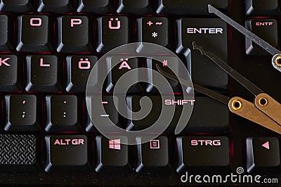 Dark environment with an illuminated keyboard and various break-in tools symbolizing cyber crime Editorial Stock Photo
