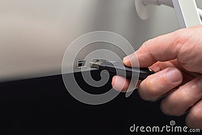 Dark flash memory connected by hand to a monitor Stock Photo
