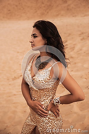 Dark girl with voluminous curly hair among the Sands in the sand dune Stock Photo
