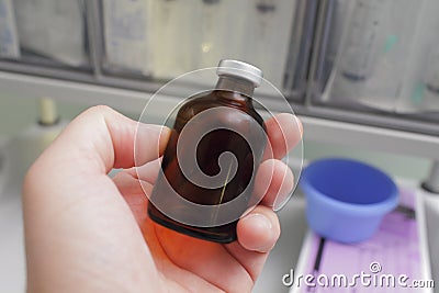 Dark glass bottle in hand laboratory worker. Stock Photo