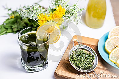 Dark green opaque drink in a glass with ice and lemon Stock Photo